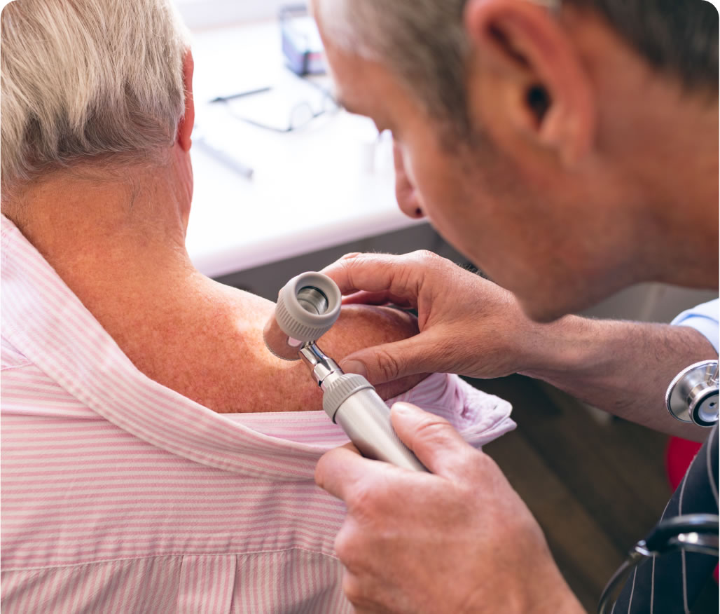 matured-male-caucasian-dermatologist-examining-sen-QTRZ4J2@2x Dermatologist examines patient